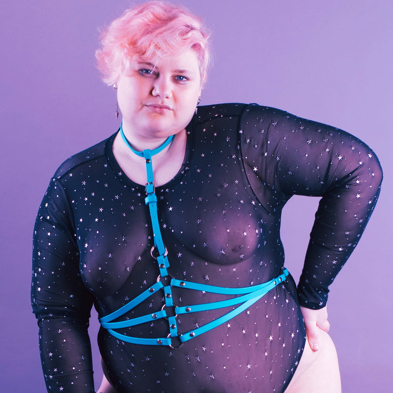 person wearing a blue waist harness over a black bodysuit.