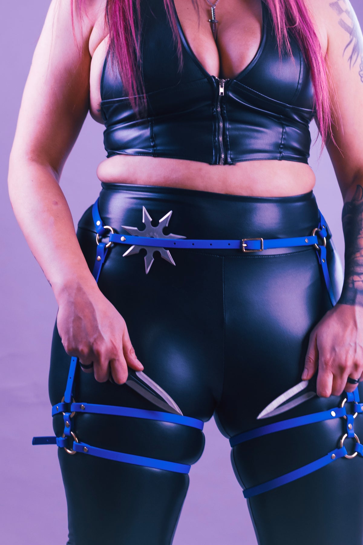 Closeup of woman in an electric blue classic thigh harness.