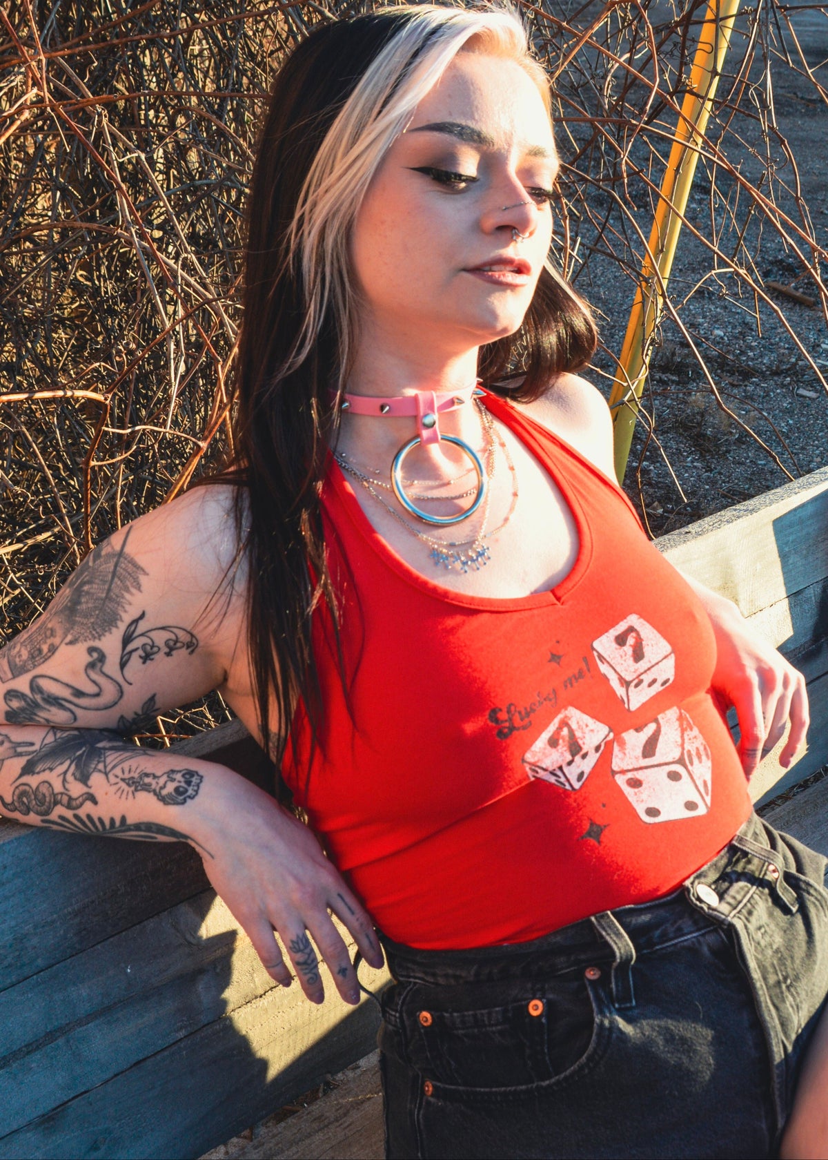 femme sitting outside wearing a pastel pink spiked collar 