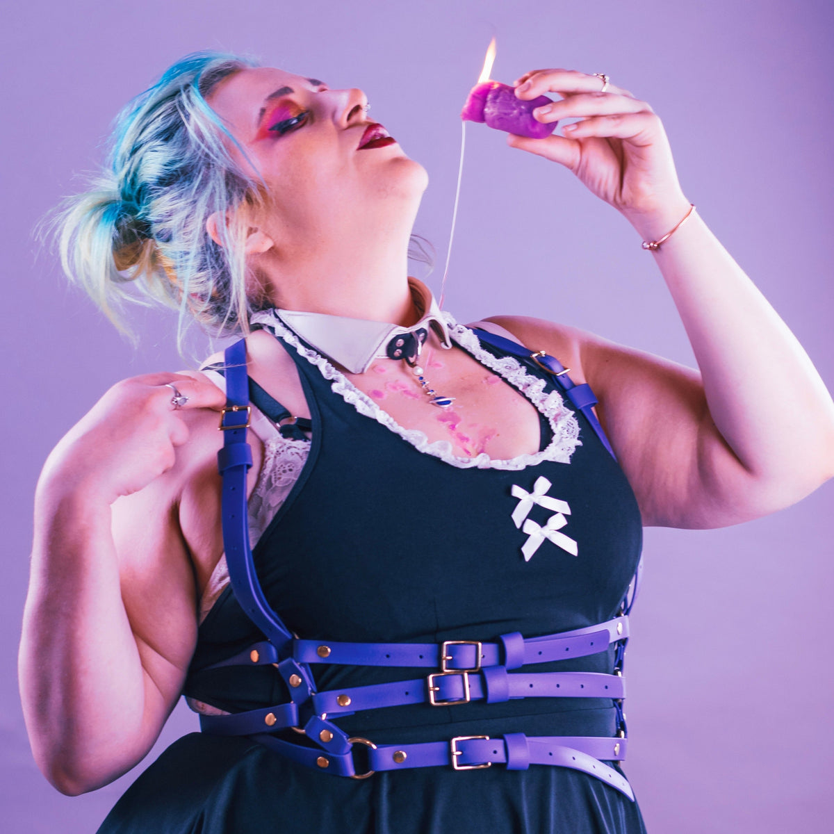 Woman in purple suspender harness and short dress.