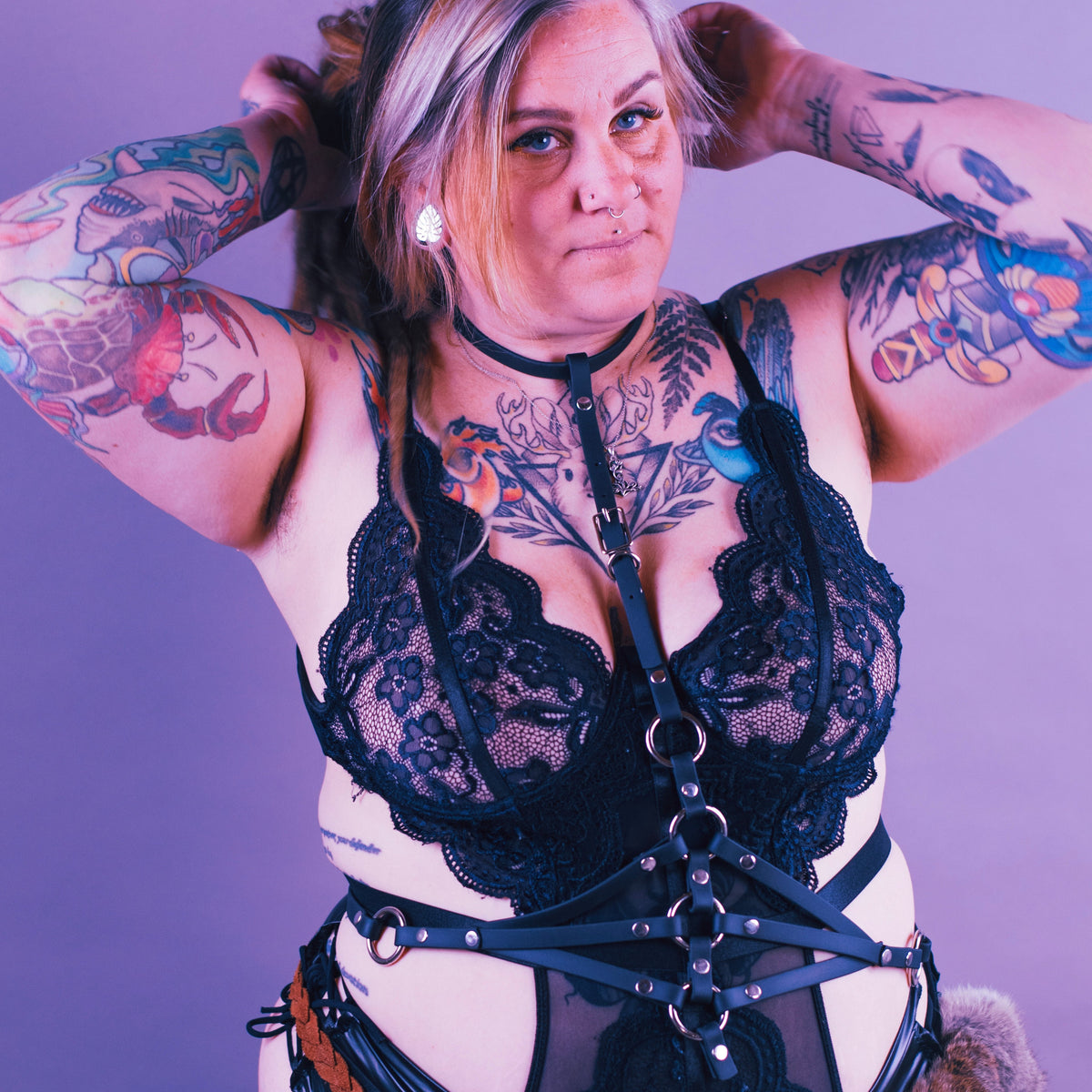 Woman wearing black lace lingerie and a black waist cinch harness.