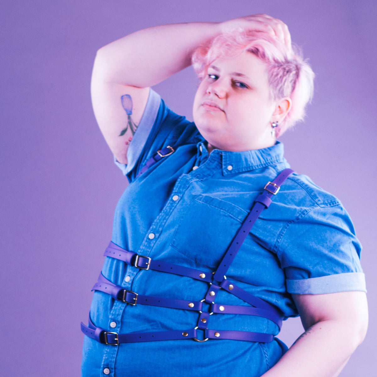 Woman styling a vegan waist harness over a shirt.